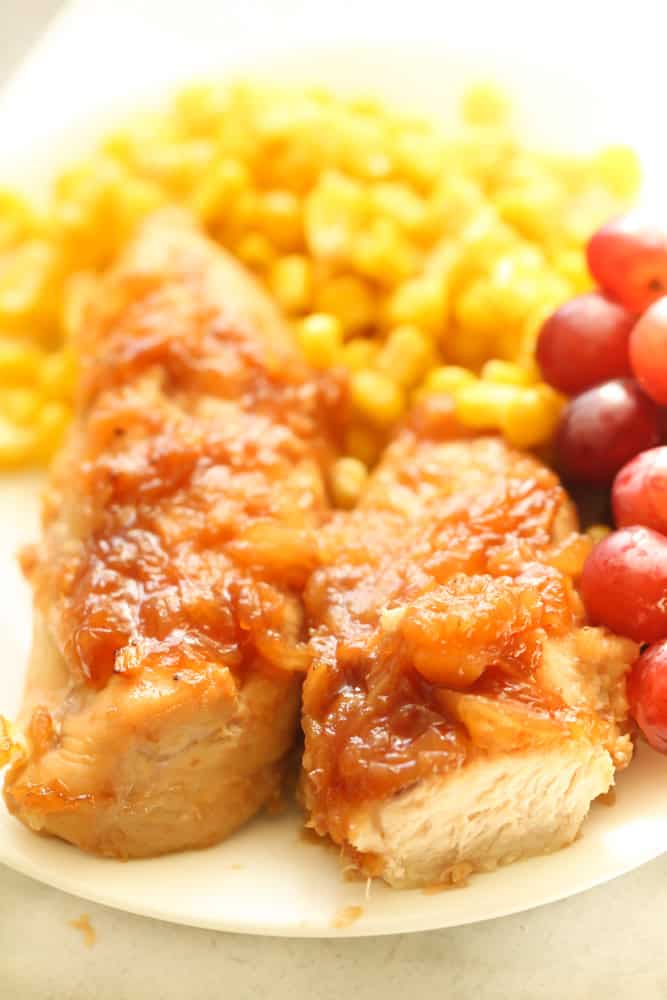 Pineapple Chicken Tenders on a plate served with corn and grapes