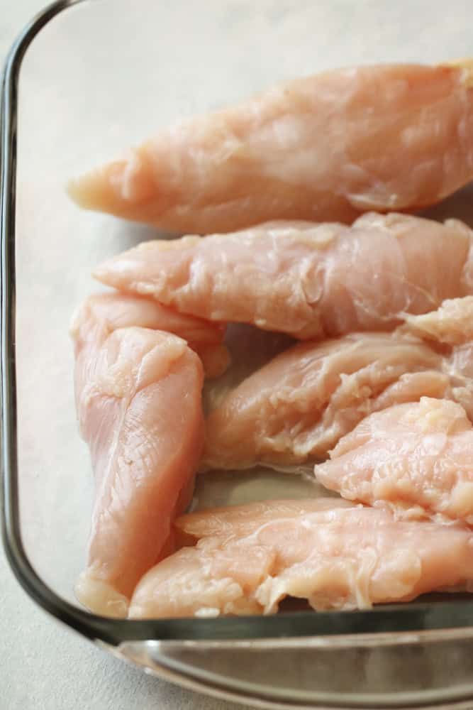 Baking dish filled with raw chicken