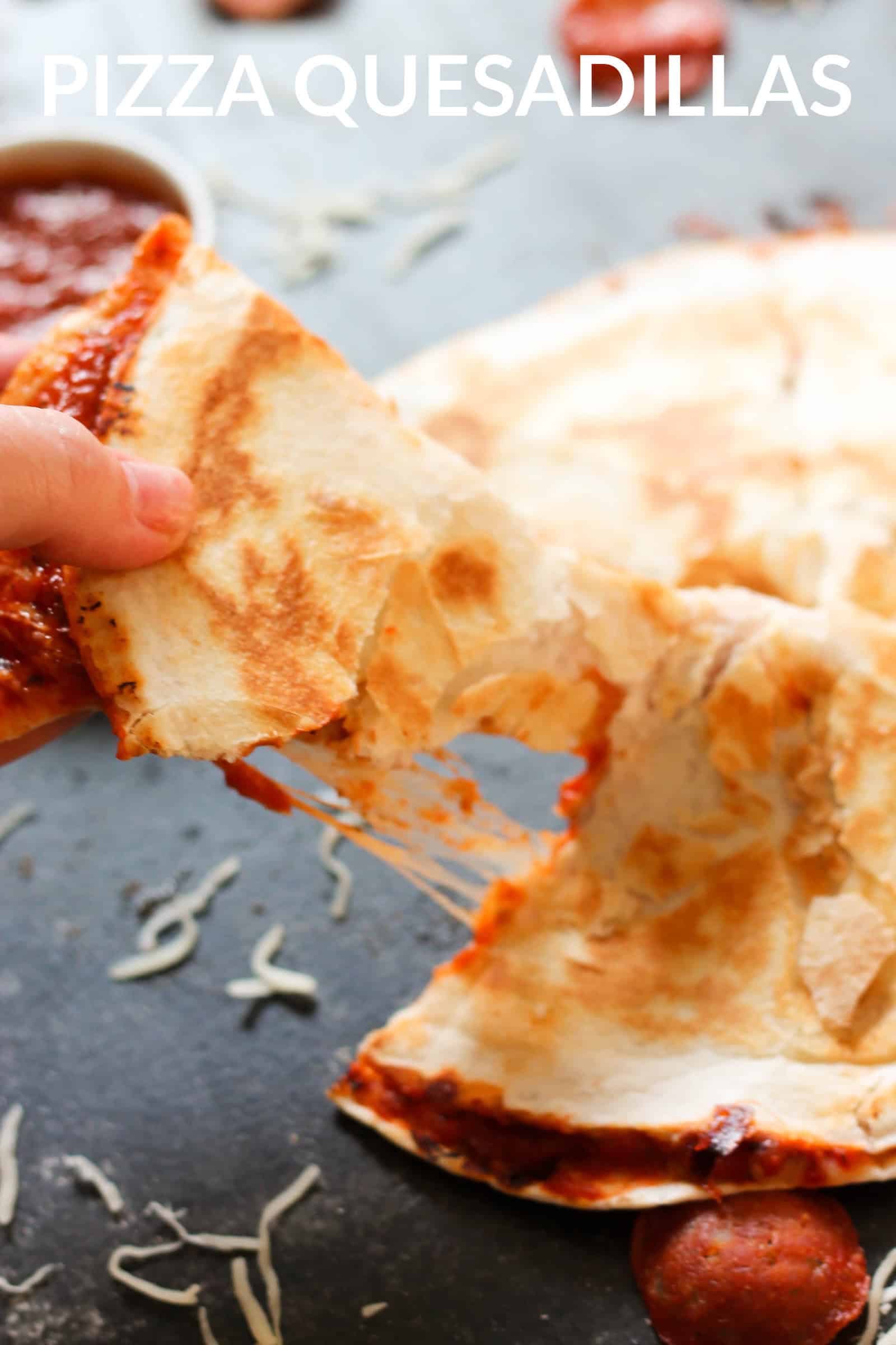 easy pizza quesadillas that have been cooked cooked, with a hand pulling out a triangle slice to eat