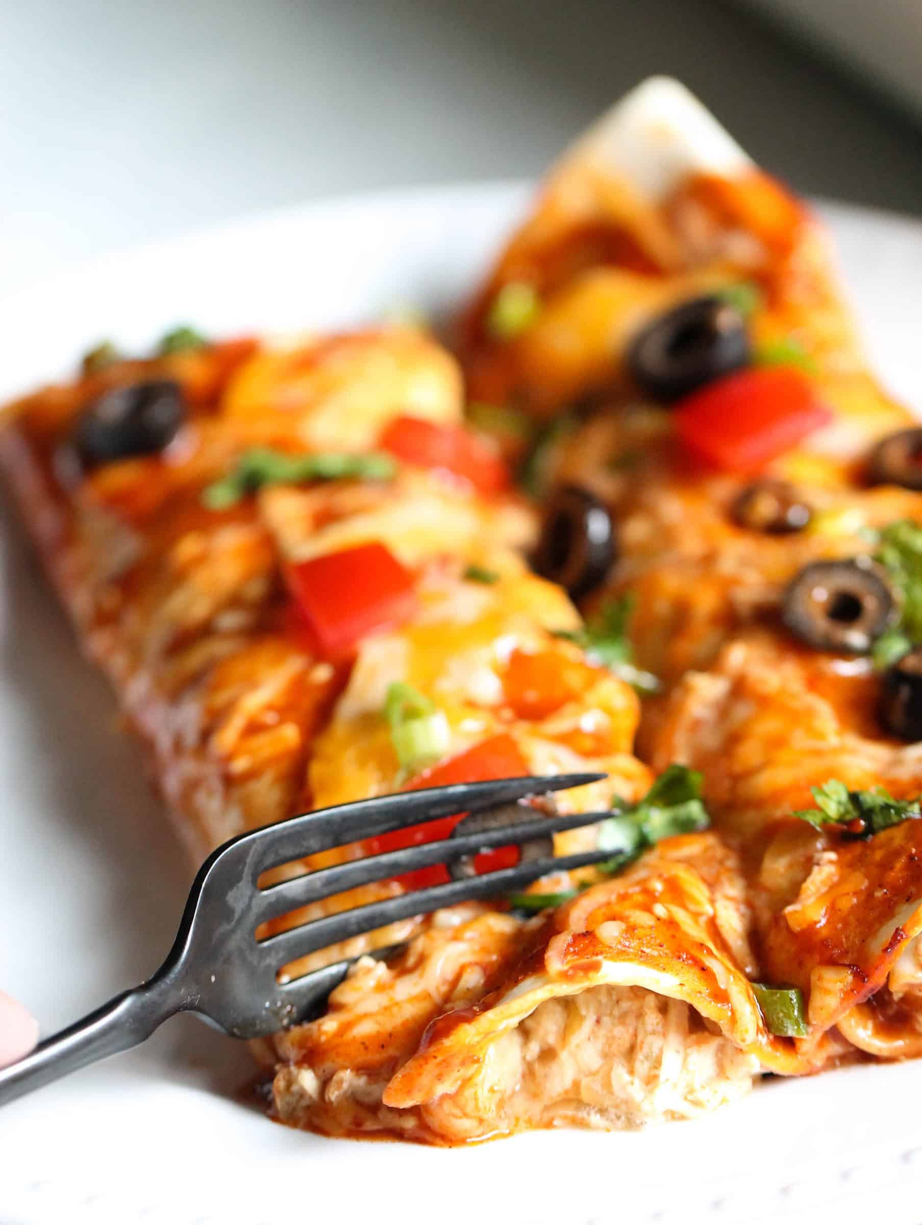 Slow Cooker Cheesy Chicken Enchiladas on a plate with a fork