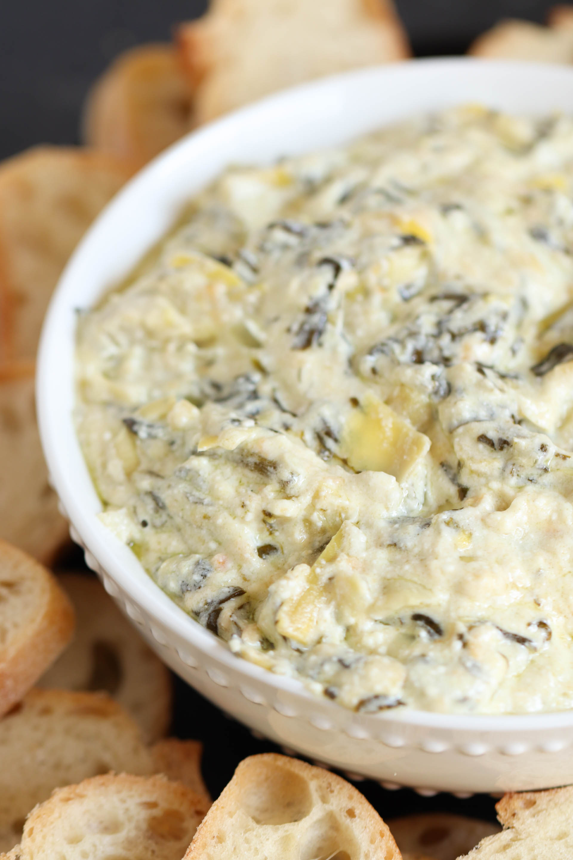 Slow Cooker Spinach Artichoke Dip  in a white bowl