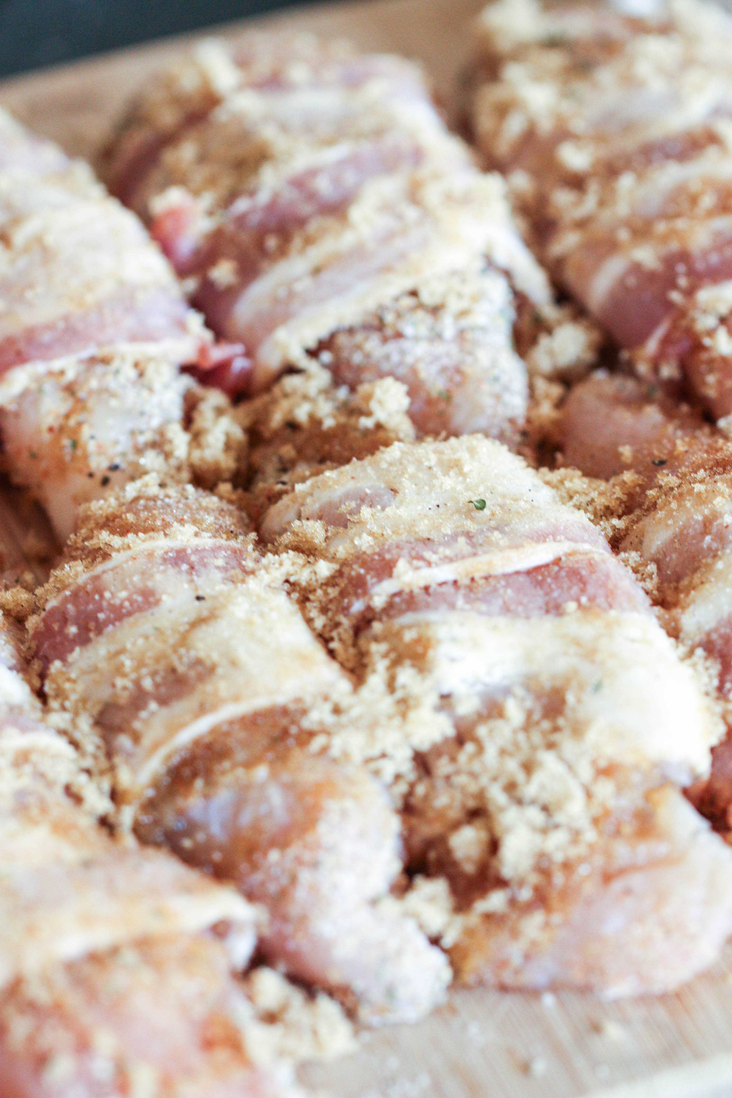 Uncooked Brown Sugar Bacon wrapped Chicken Tenders on Baking sheet
