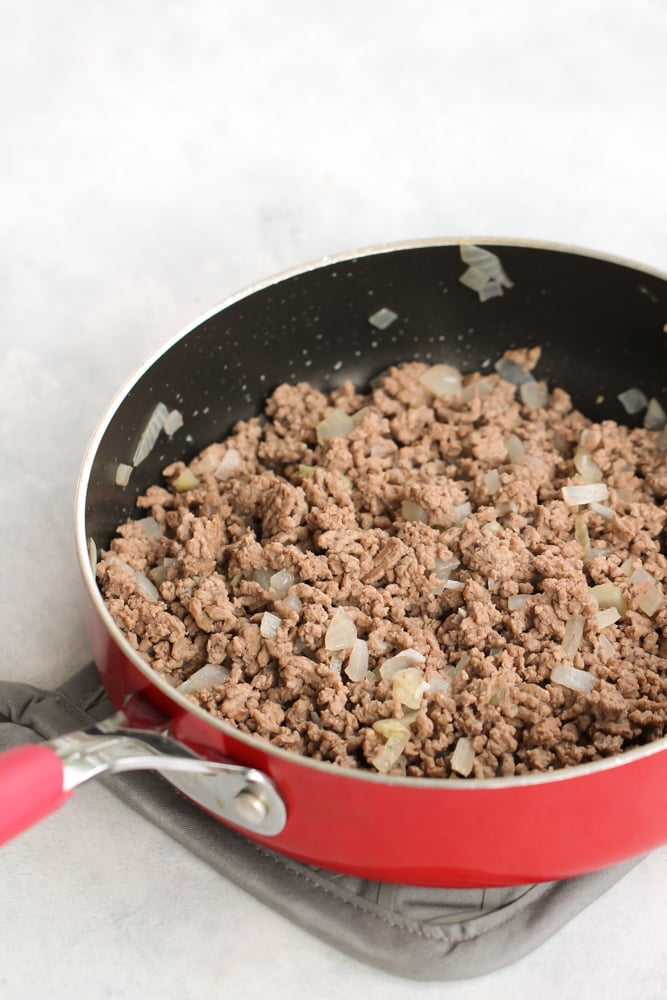 Skillet with cooked ground beef and onions