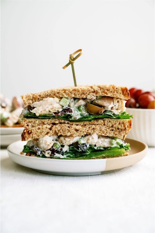 Chicken Salad Sandwich cut in half on a plate with a toothpick in the middle of it