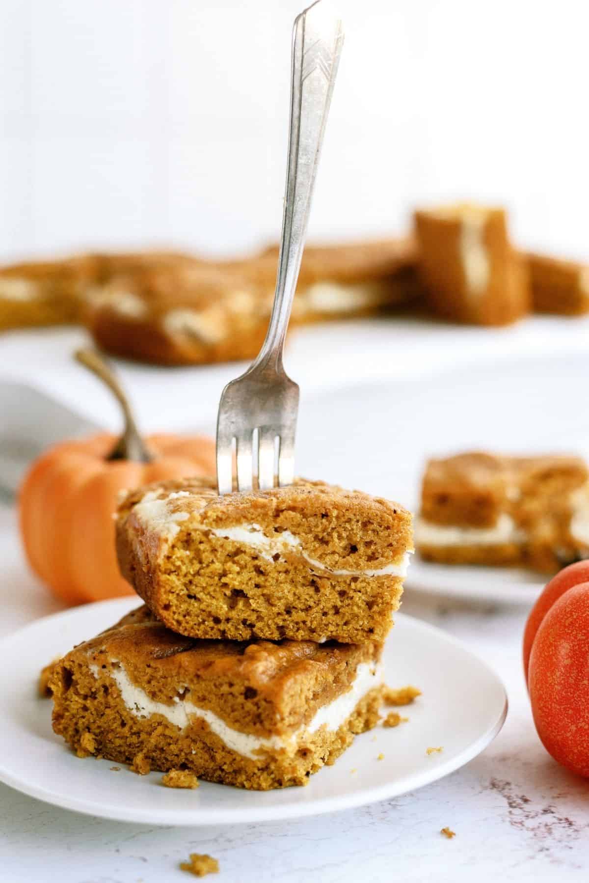 Cream Cheese and Pumpkin Roll Bars on a plate with a fork in them