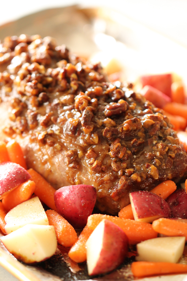Maple Pecan Pork Tenderloin on a serving plate with carrots and potatoes