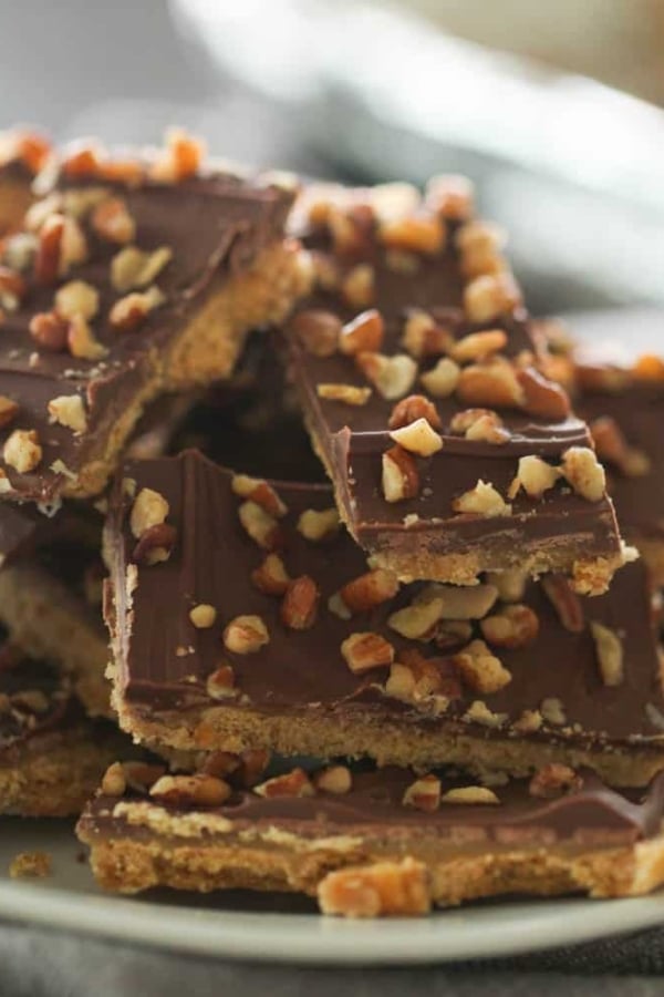 A plate of chocolate toffee bars topped with chopped nuts.