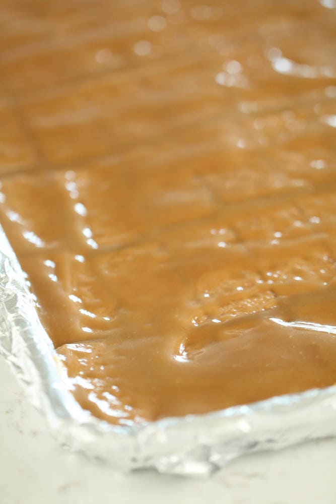 Baked toffee on top of graham crackers in a pan