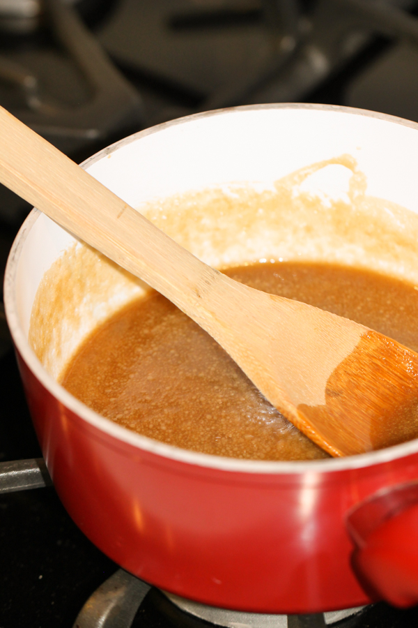 Sugar and butter mixture melted in saucepan with wooden spoon
