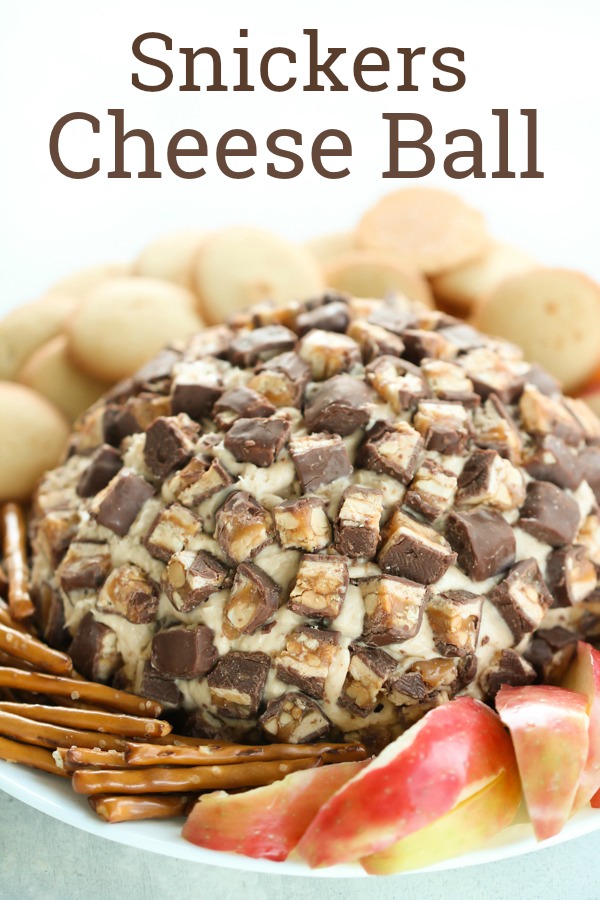 Snickers Cheeseball with apples and pretzels on a plate