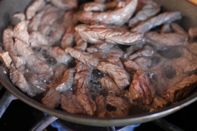 Steak sautéing in pan