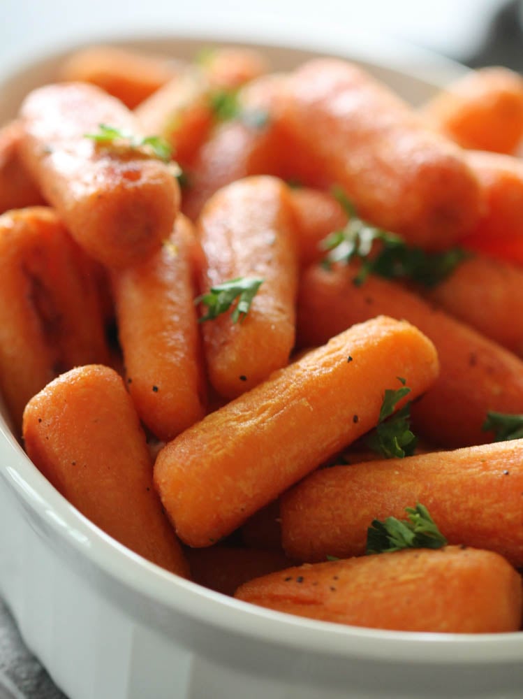 Honey Roasted Carrots in white bowl  with fresh parsley