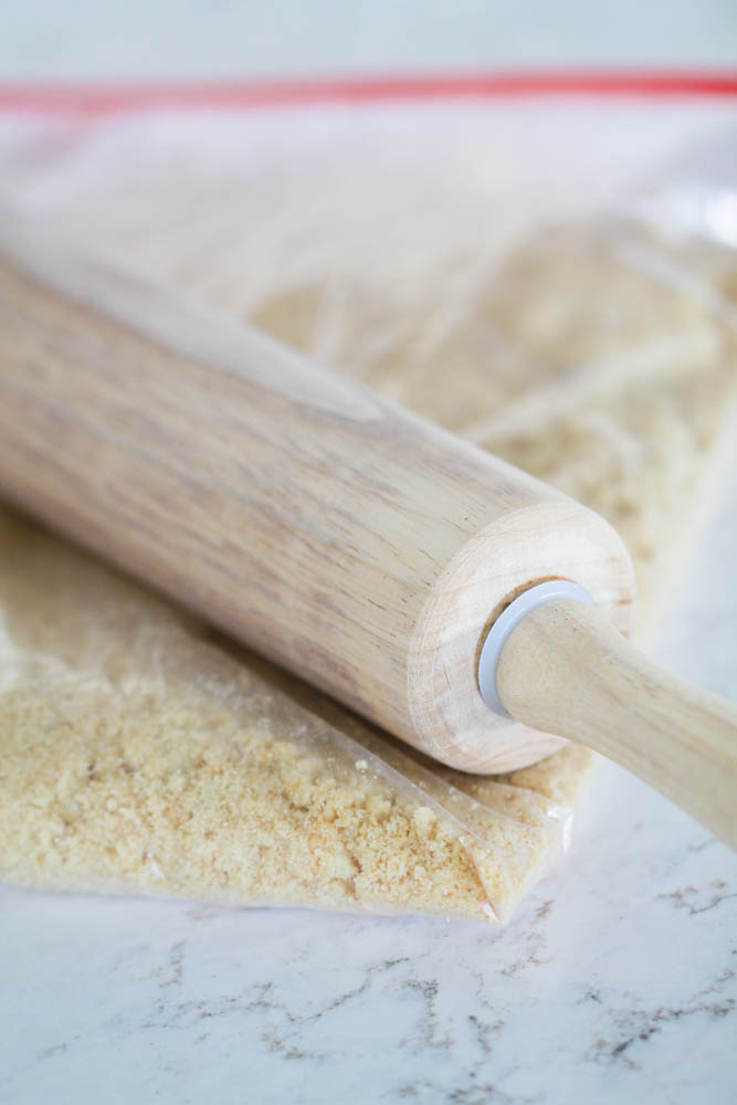 sugar cookie crumbs being smashed with a rolling pin