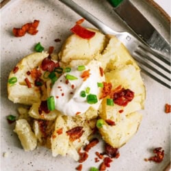 An Instant Pot Baked Potato on a plate with toppings.