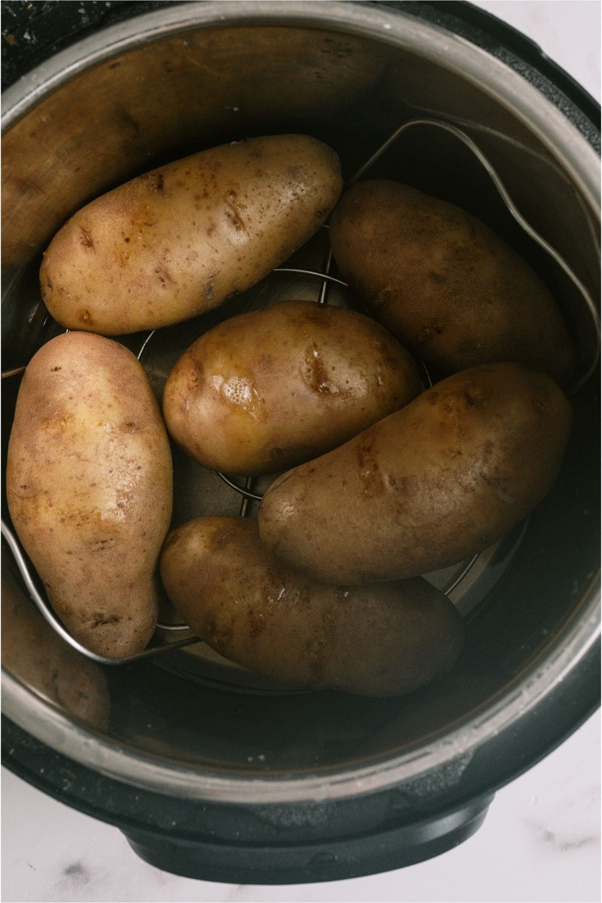 Large Russet potatoes in the instant pot with water.