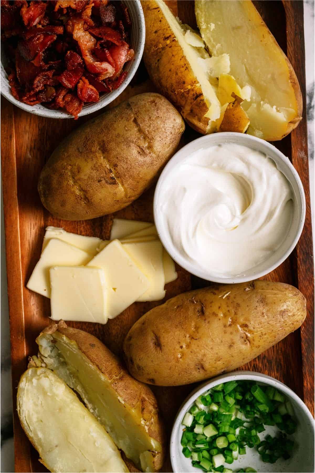 Instant Pot Baked Potatoes on a tray with with toppings.