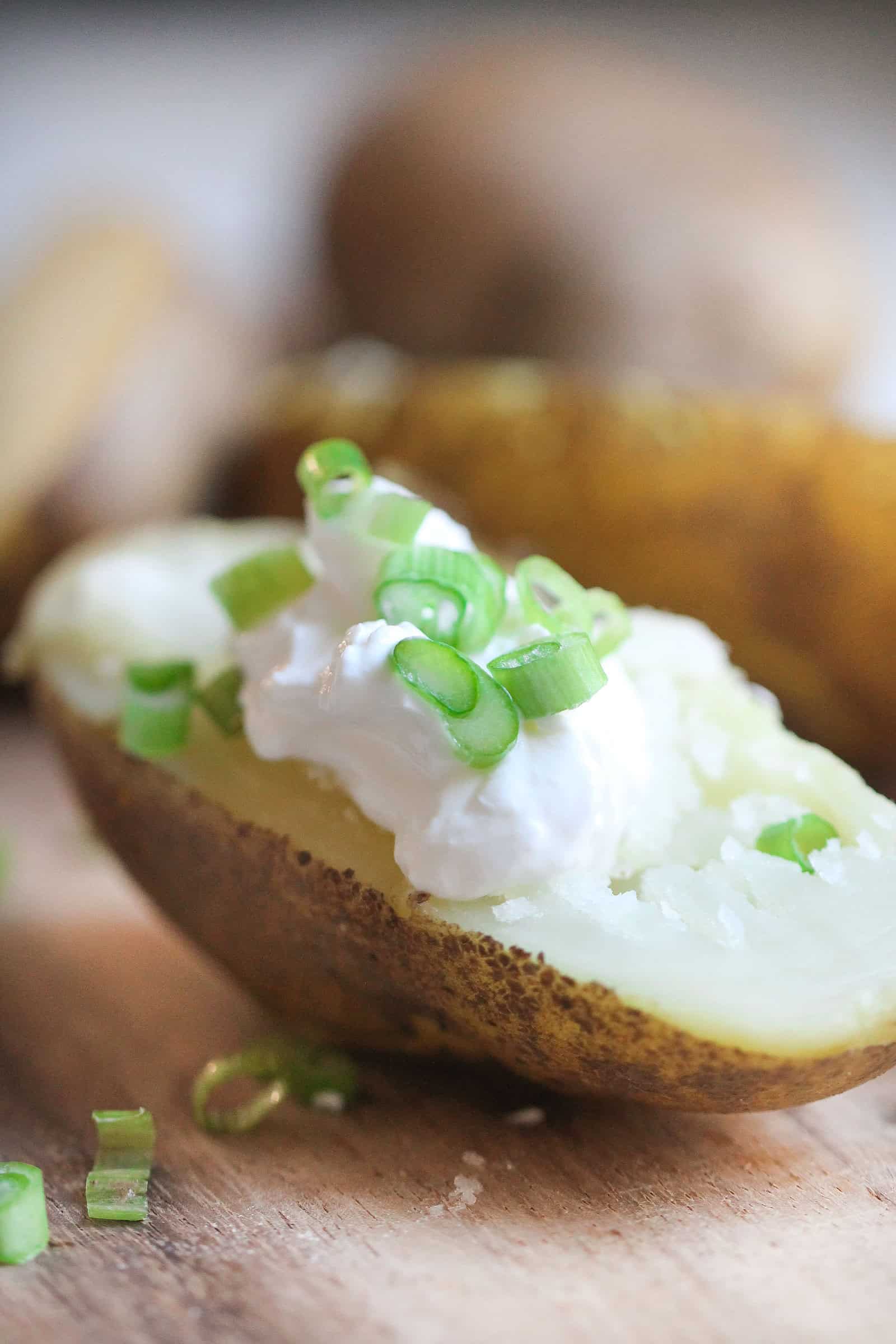 Baked potato topped with sour cream and green onions