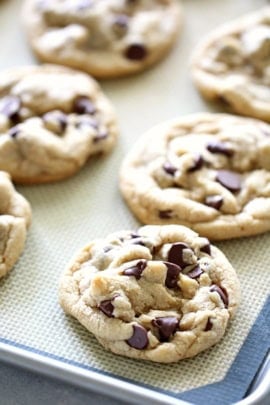 Baked chocolate chip cookies on a lined pan.
