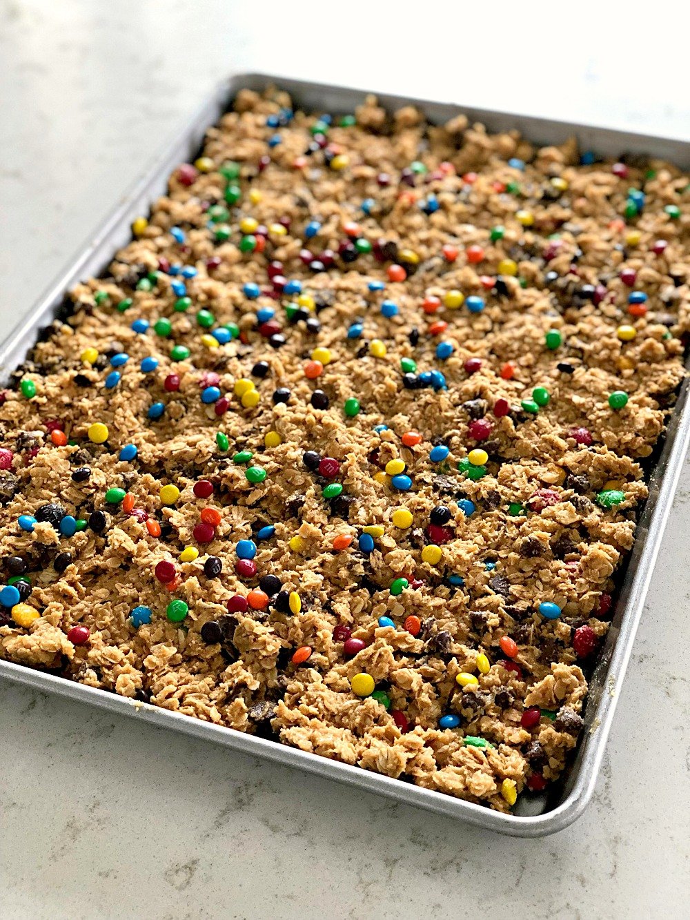 Unbaked M&M Oatmeal Cookie Bars in cookie sheet