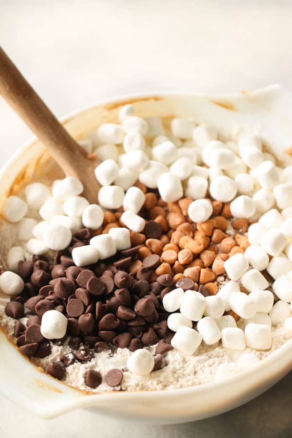 Ingredients for Butterscotch Chocolate Chip Blondies in a mixing bowl with a woden spoon.