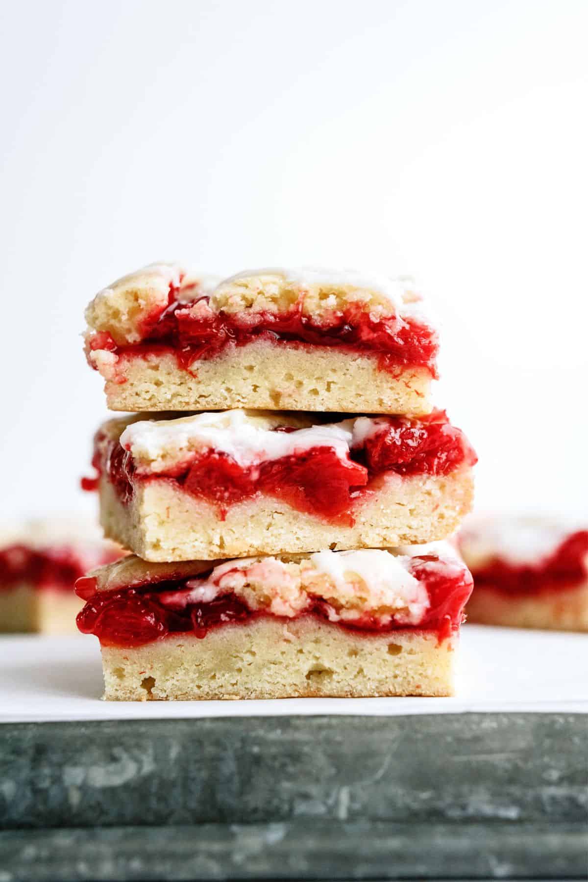 Cherry Pie Bars Recipe stacked on top of a baking sheet