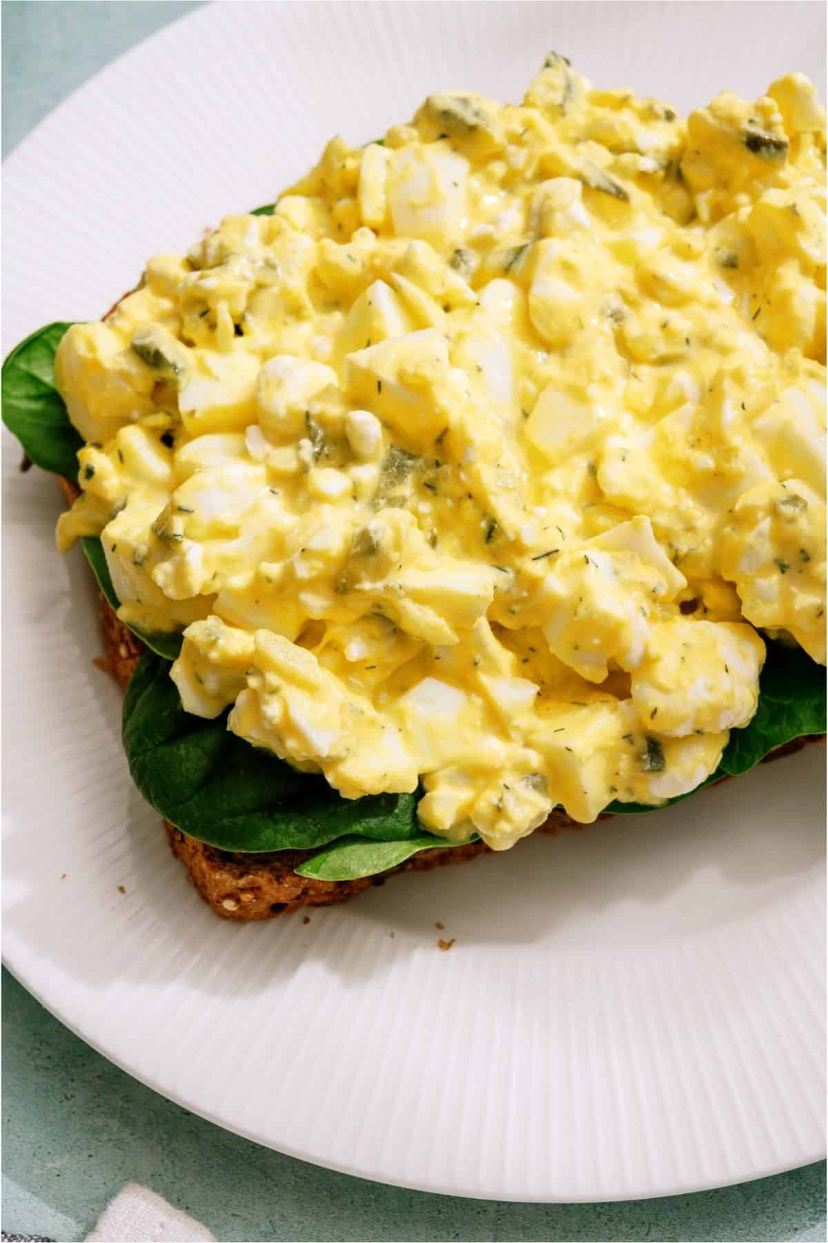 A slice of bread topped with lettuce and High Protein Egg Salad.