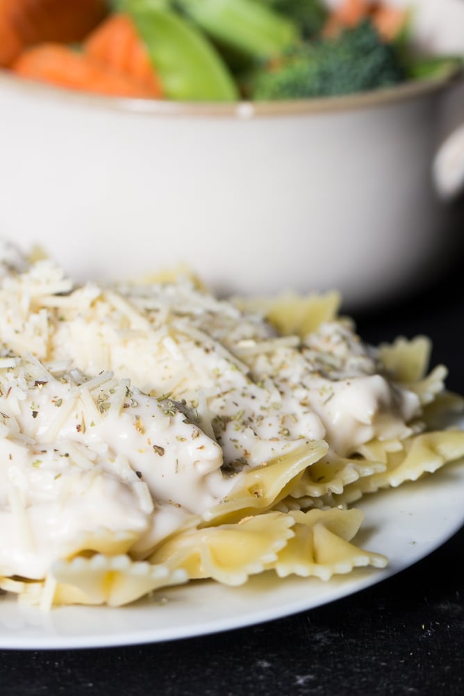 Slow Cooker Easy Alfredo on a plate with a side of vegetables