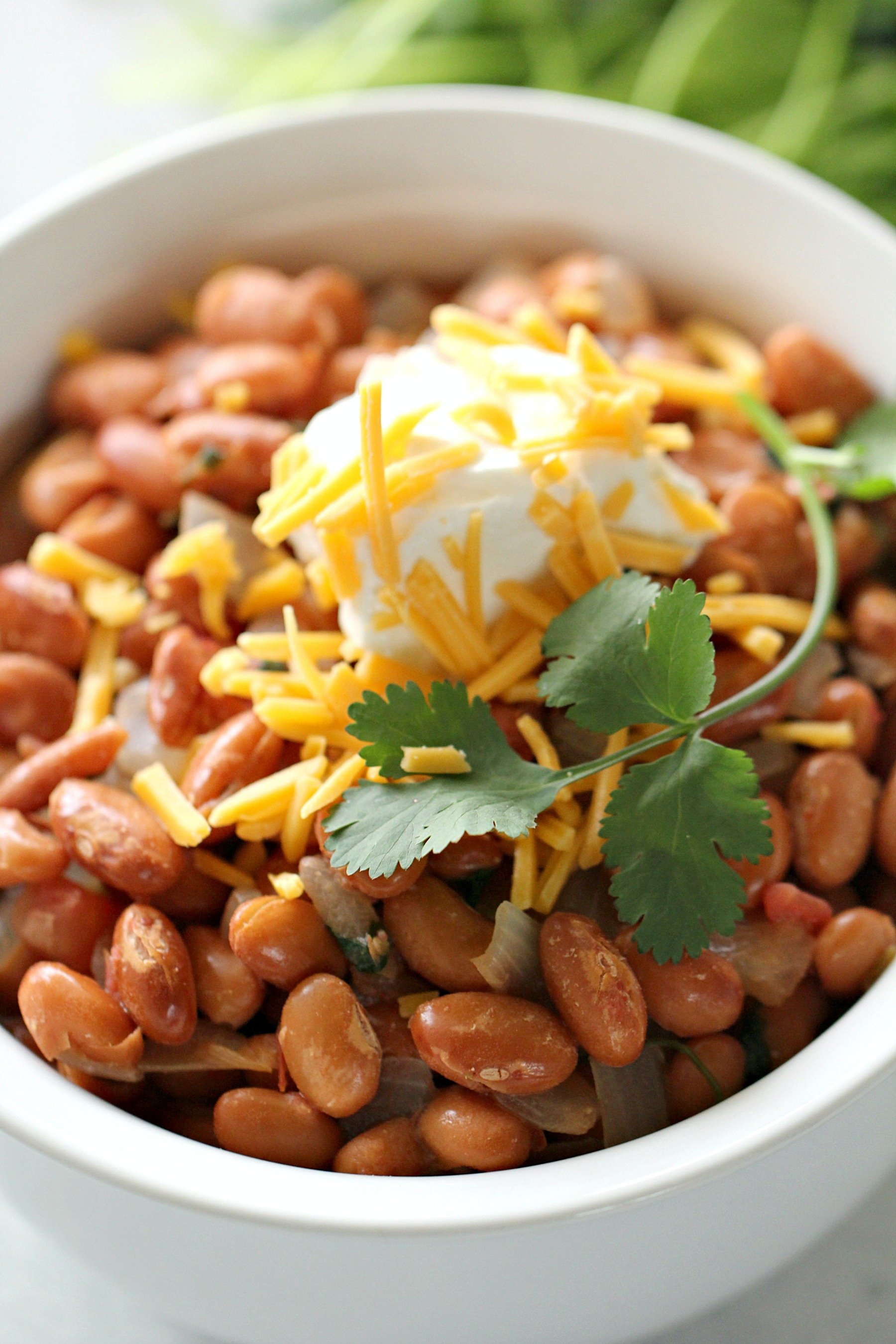 Close up of a bowl of Easy Texas Pinto Beans with toppings