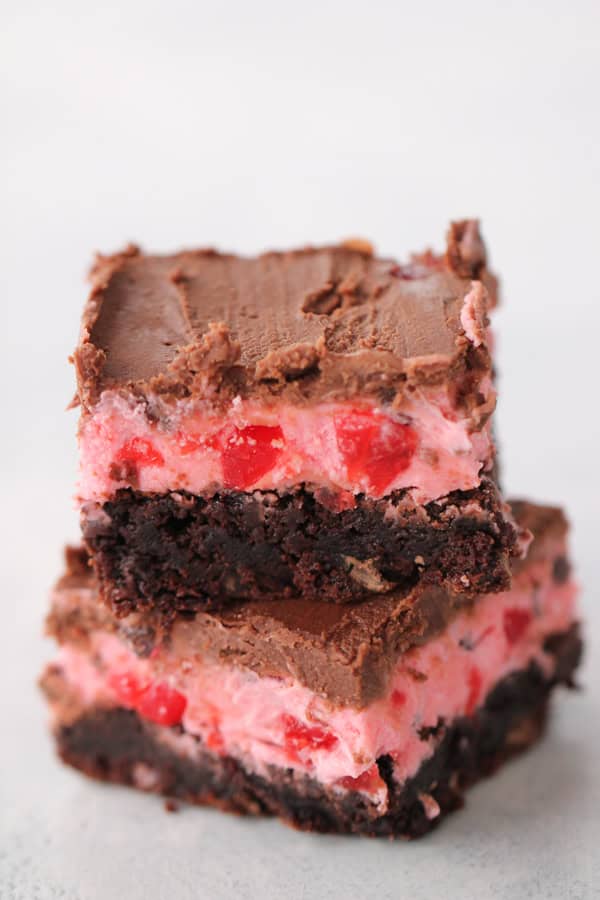 2 Chocolate Cherry Chunk Brownies stacked on top of each other on a white plate.