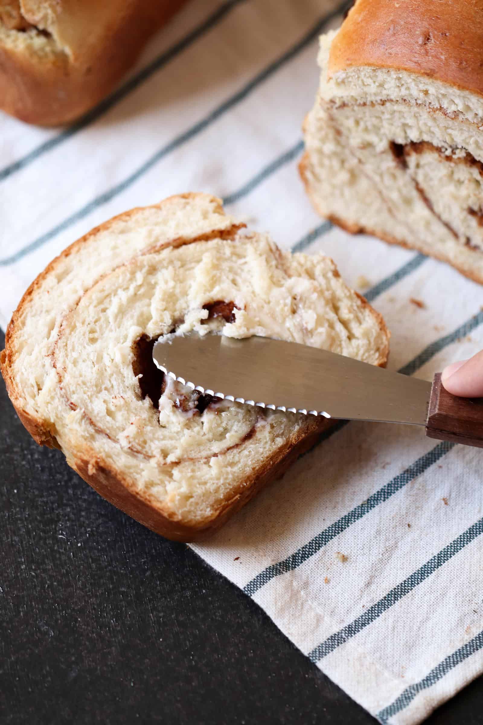 Spreading butter on a slice of Cinnamon Swirl Bread