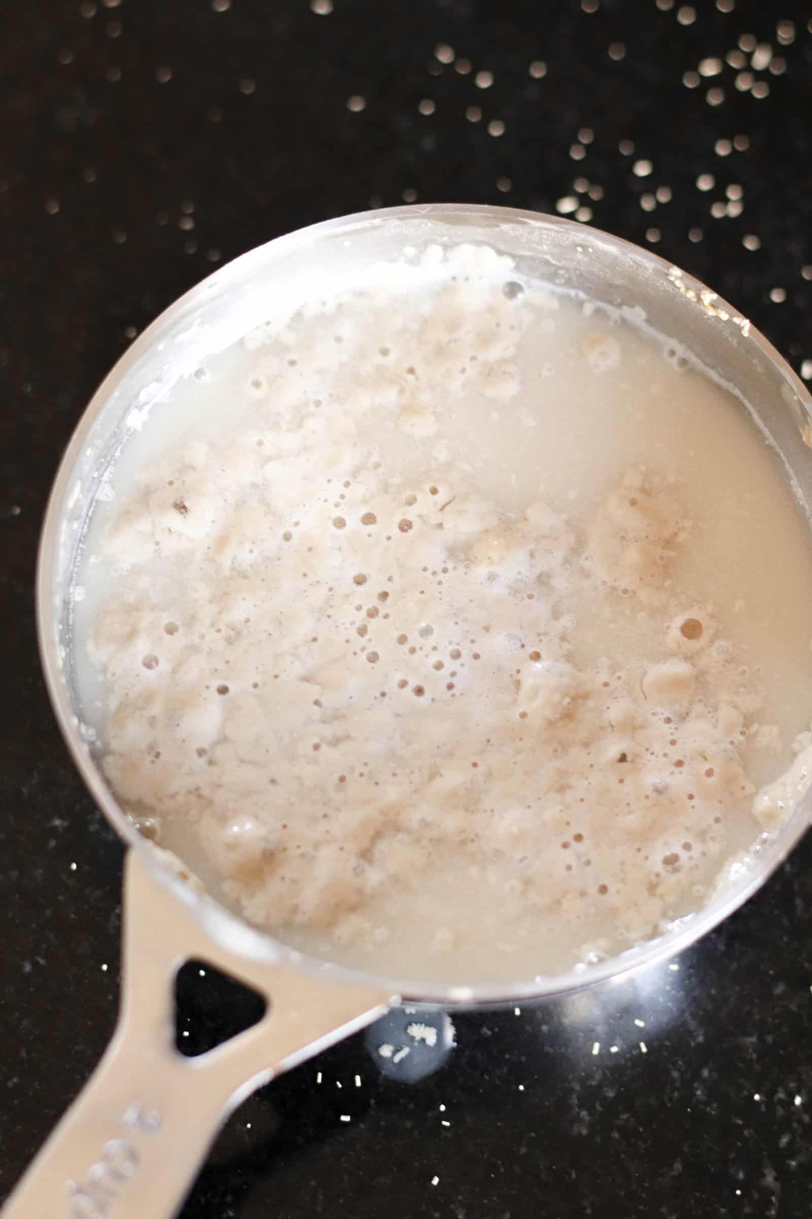 Yeast and water mixed together in measuring cup