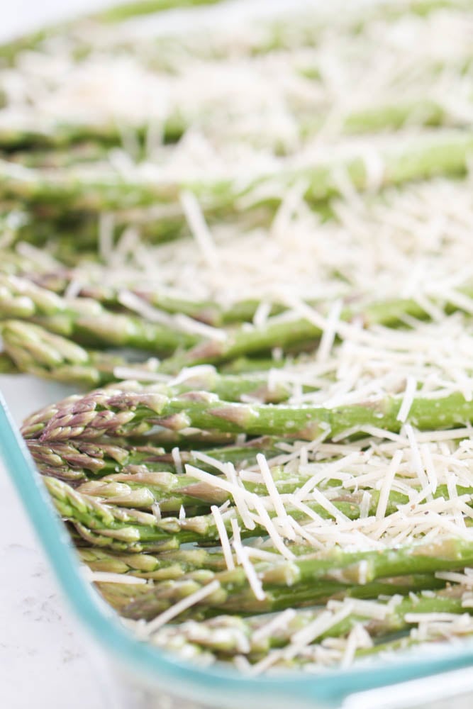 Washed asparagus in a pan with parmesan cheese sprinkled on top