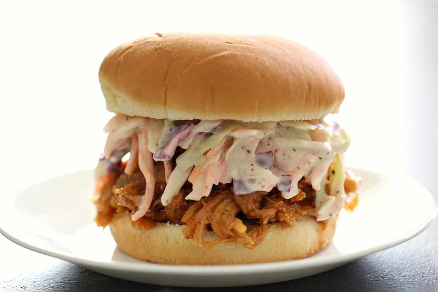 BEST Slow Cooker BBQ Pulled Pork and Coleslaw Sandwich on a white plate