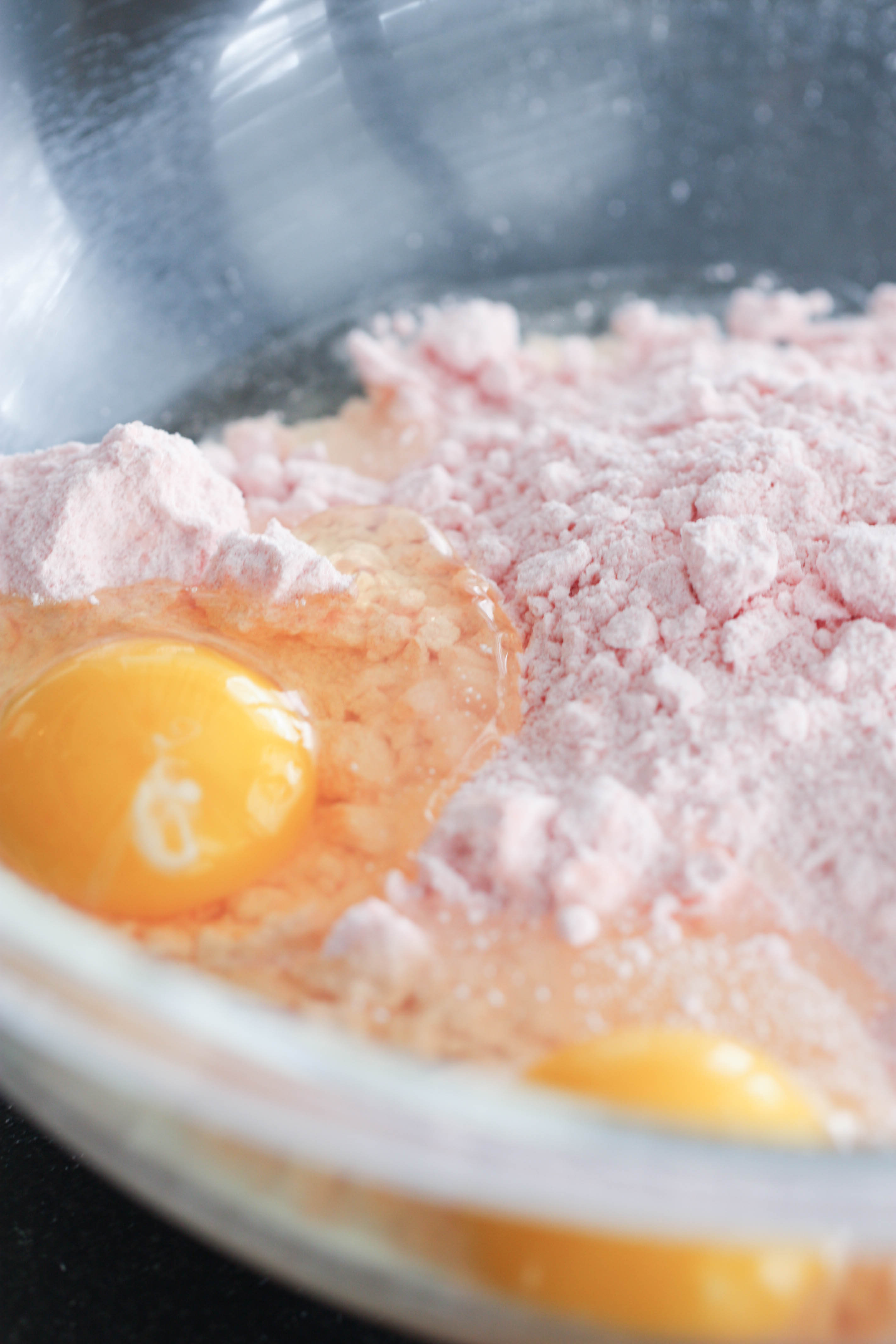 Strawberry cake mix with eggs in a glass bowl