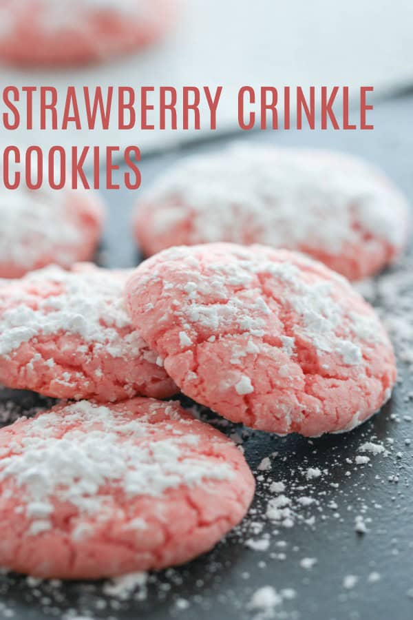 Strawberry Crinkle Cookies on baking sheet with powdered sugar.