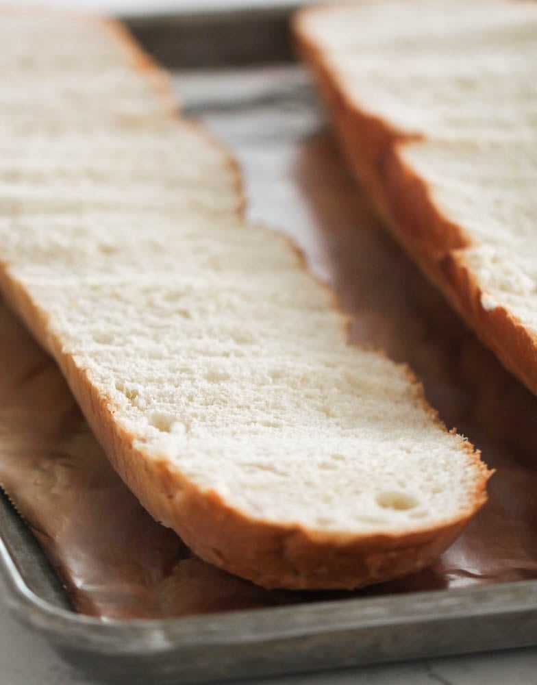 French bread cut lengthwise on a sheet pan