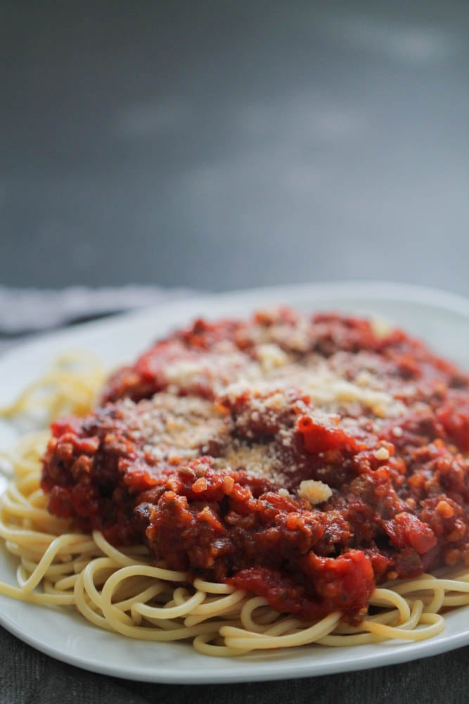 Slow Cooker Bolognese served over spaghetti on a plate