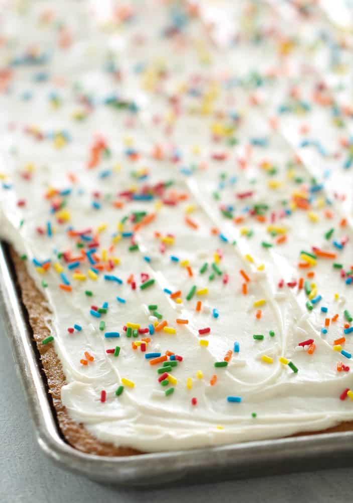 White Texas Sheet Cake frosted with sprinkles in a sheet pan.