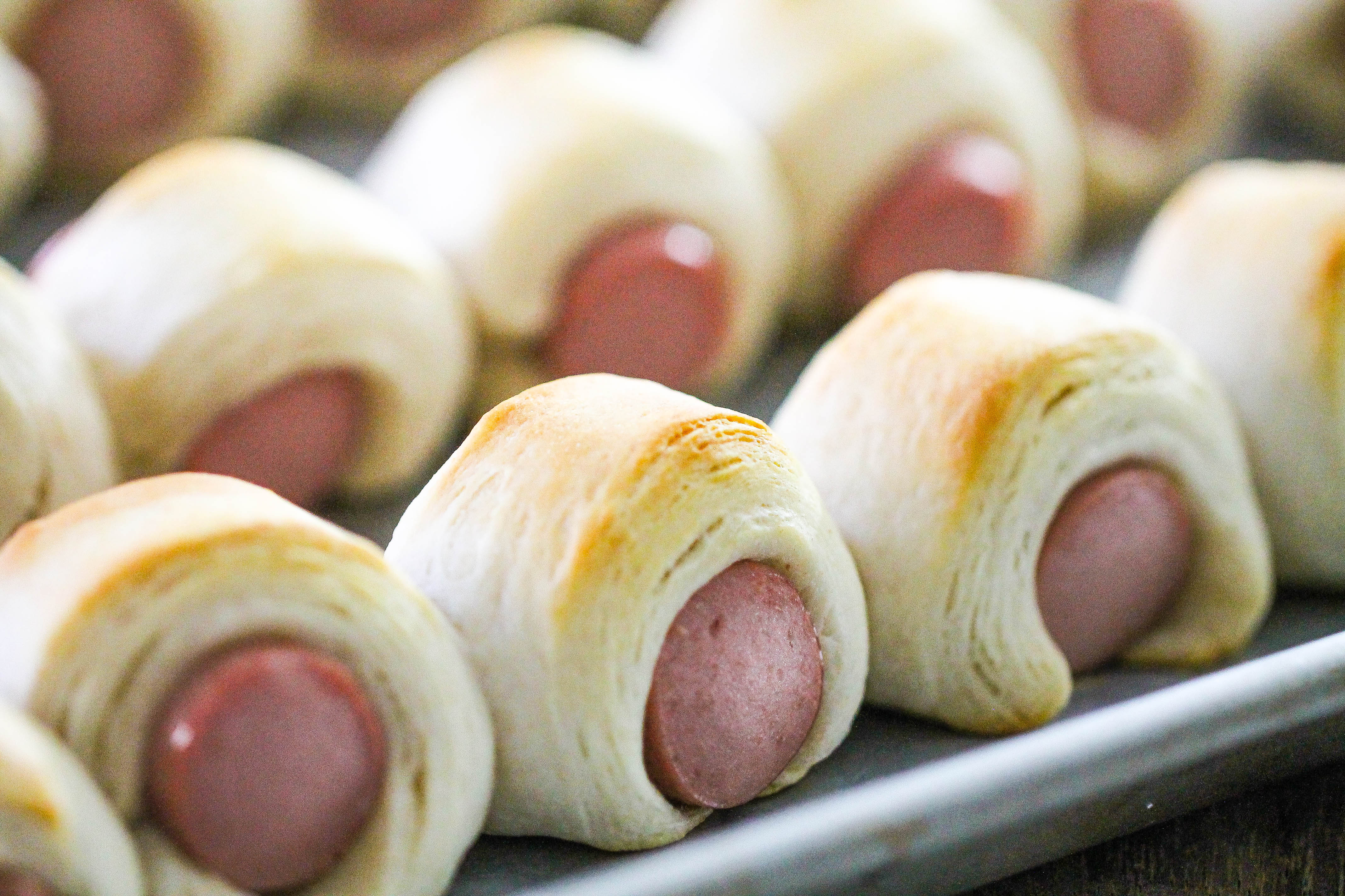 Classic Pigs in a Blanket lined up on a baking sheet