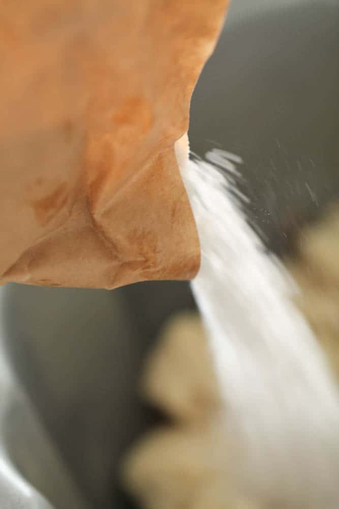 Cook 'n' serve pudding mixture being poured over thawed rolls in the bottom of a bundt pan