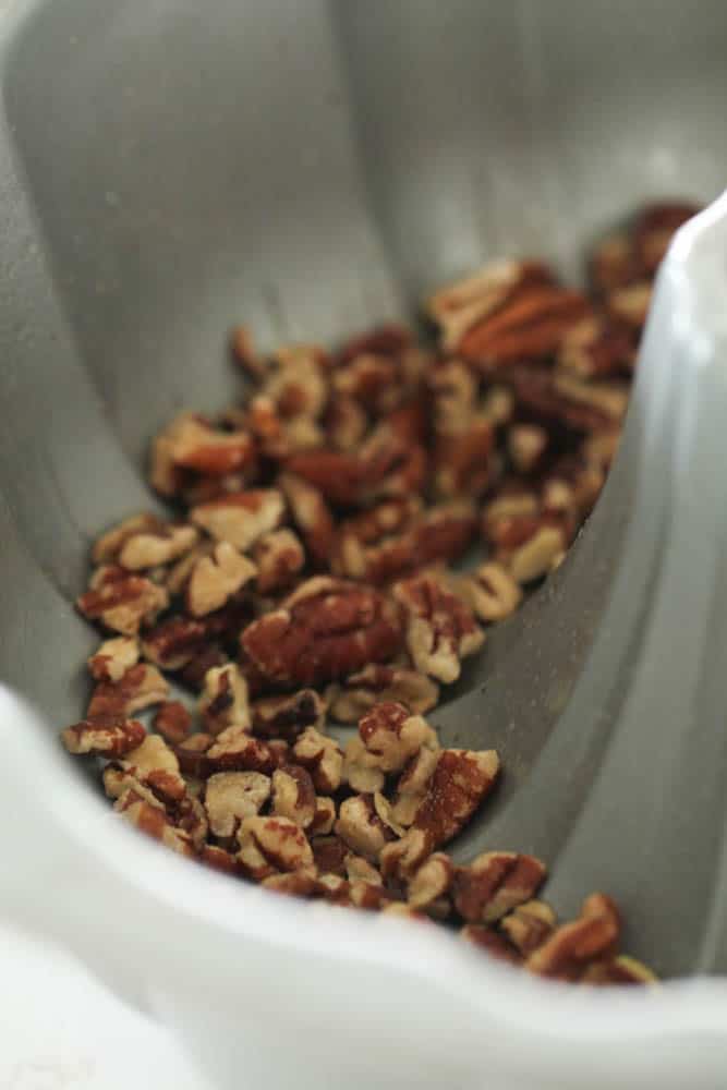 Chopped pecans in the bottom of a sprayed bundt pan