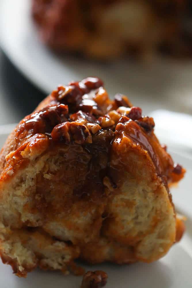 a piece of gooey caramel pull apart on a plate, waiting to be eaten