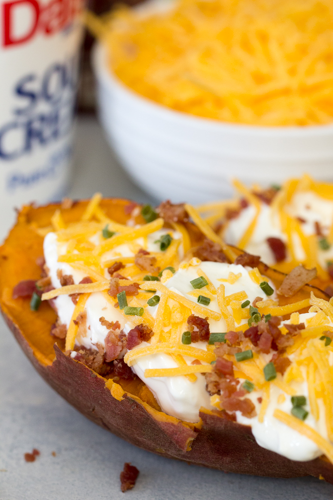 Baked sweet potato topped with sour cream, bacon bits and chives