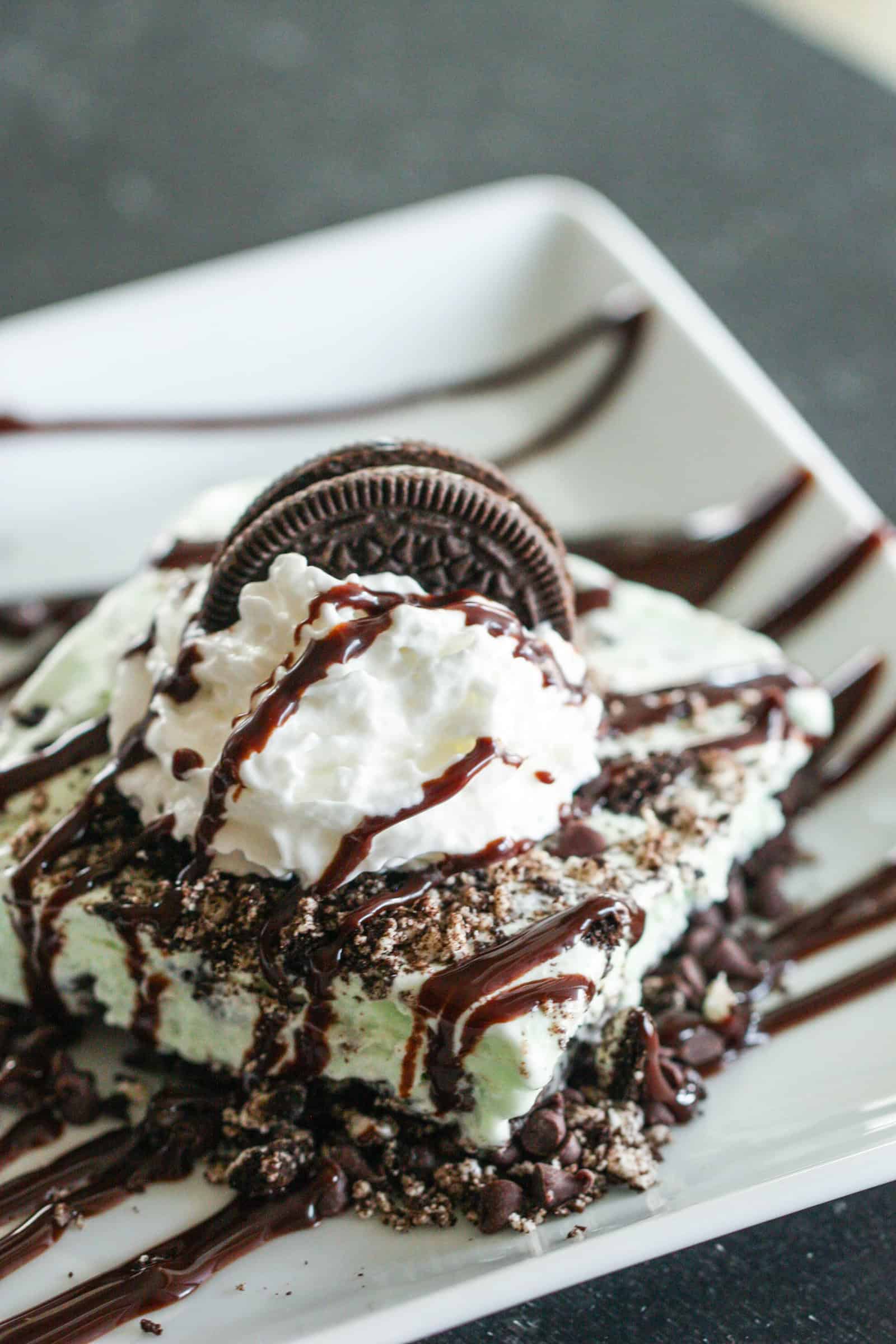 Slice of Asphalt Sheet Cake Pie topped with whip cream and oreo cookie
