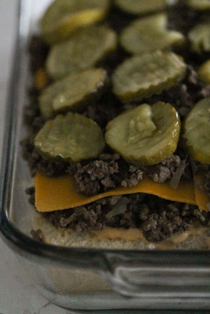 hambuurger on sliders topped with cheese pickles