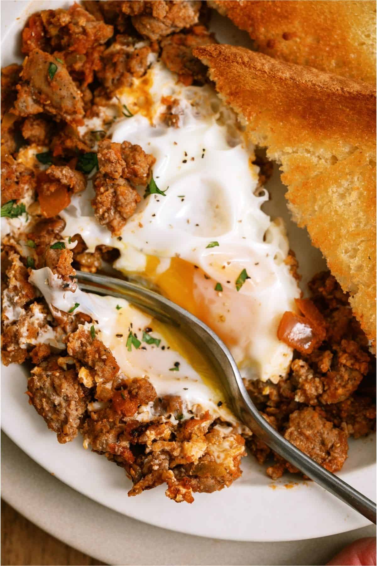 A fork slicing into a serving of One Pan Egg and Turkey Skillet on a plate.