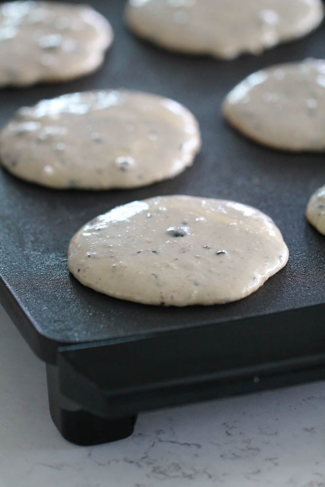 Blueberry Protein Pancakes batter on a hot griddle