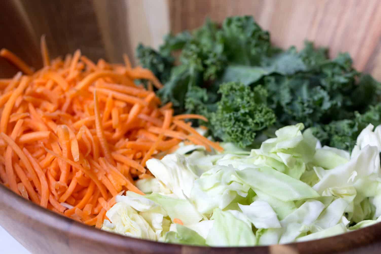 Carrots, lettuce and kale in a mixing bowl