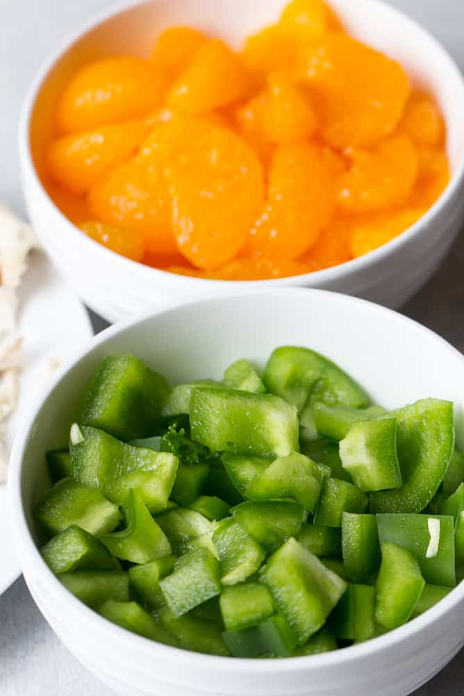 2 small bowls filled with oranges and peppers