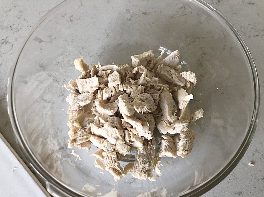 Shredded Chicken added to glass mixing bowl